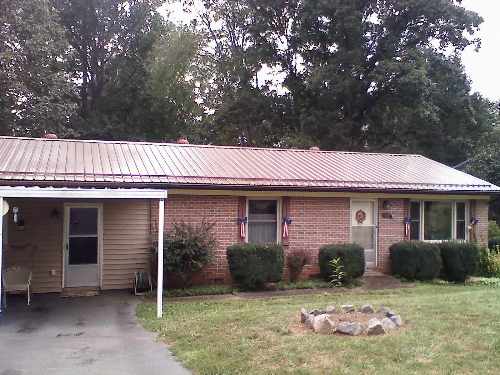 Bronze metal roof and carport on a brick ranch home — Roof Repair work by our crew in Flagler Beach